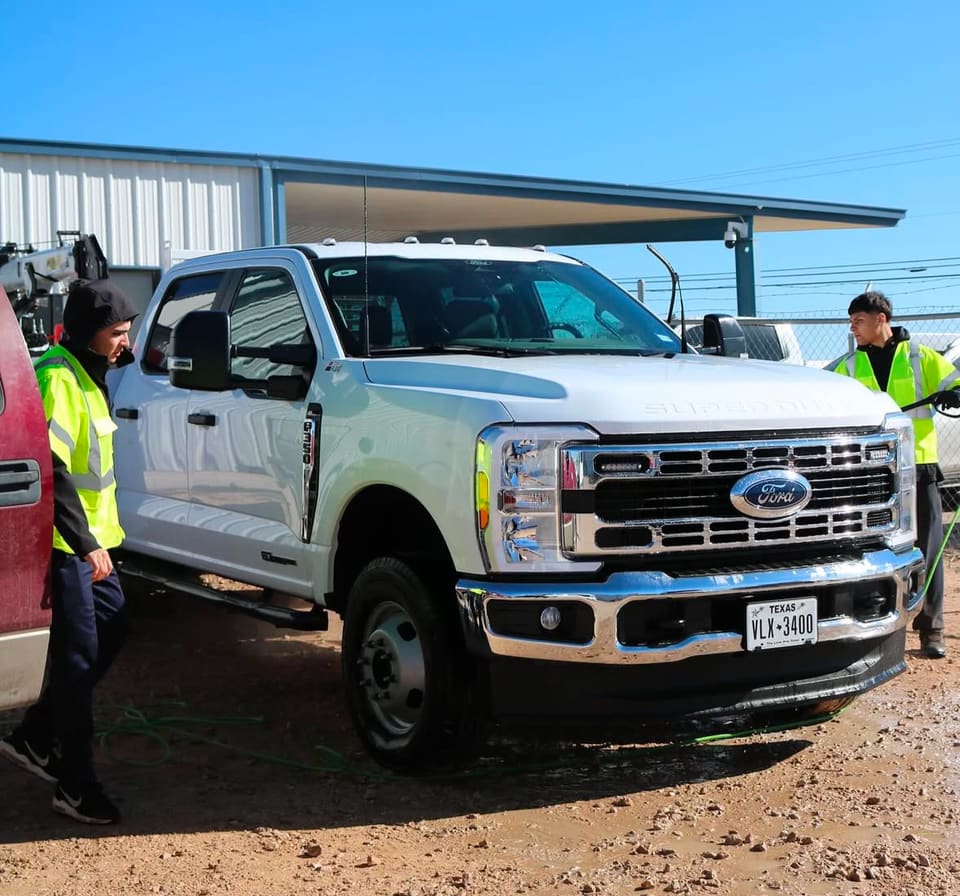 A crew detailing a white Ford fleet truck