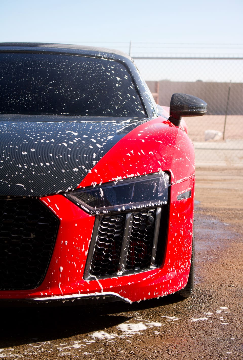 Foam covering the carbon bonnet and red bodywork of an Audi R8 during a wash